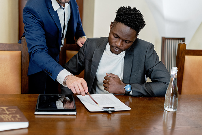 young man in a gray suit looking at a document